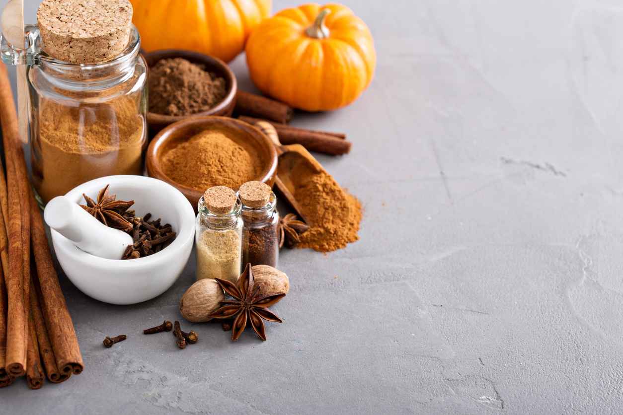Homemade pumpkin pie spice in a glass jar with ingredients